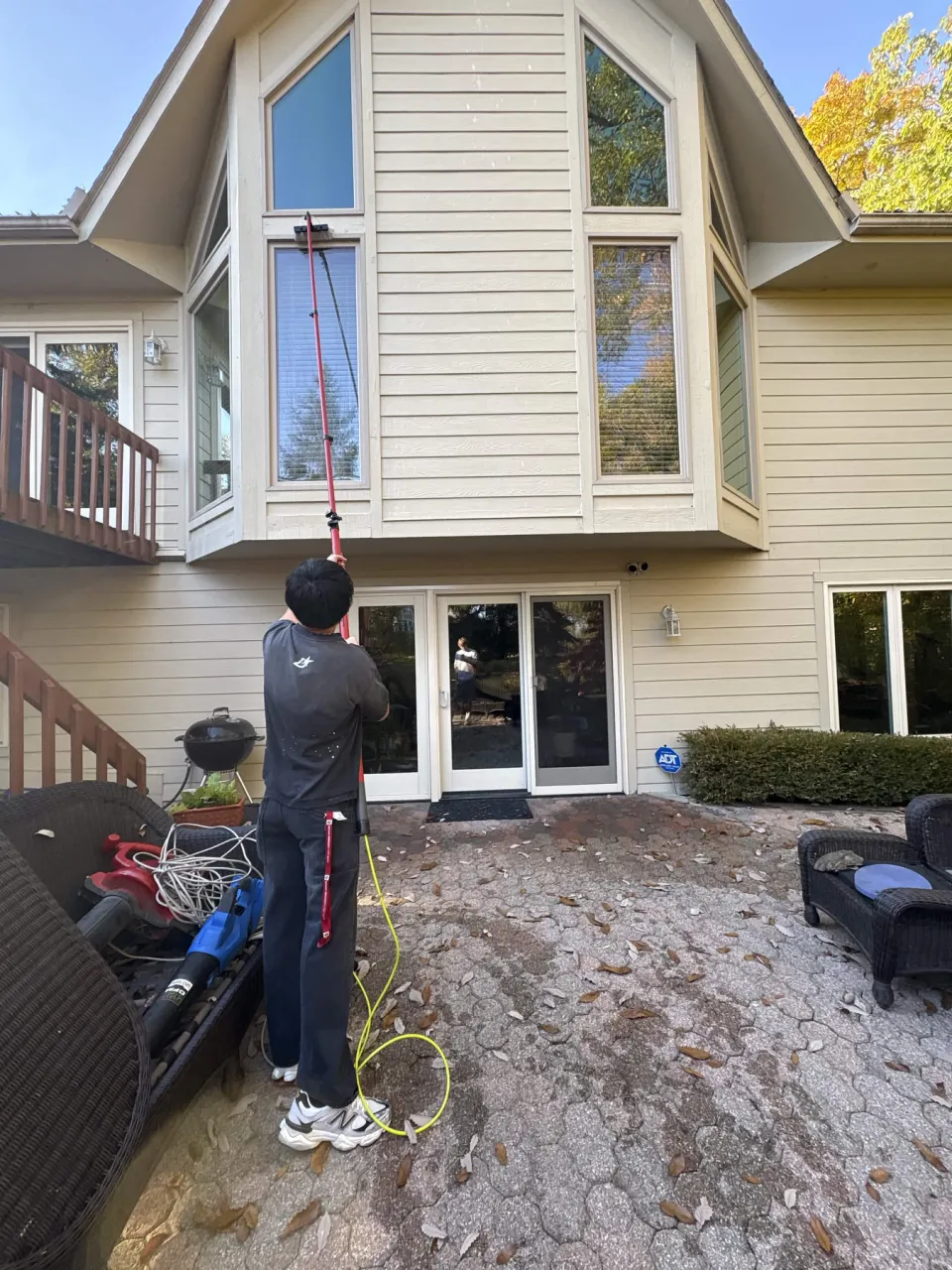 ShinePro cleaning tall second-story windows from the ground