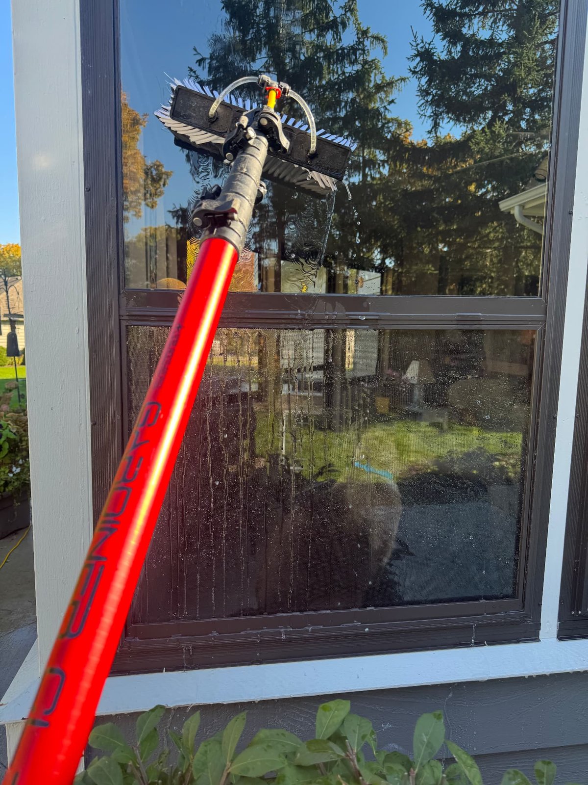ShinePro water-fed pole and brush cleaning a double-hung window